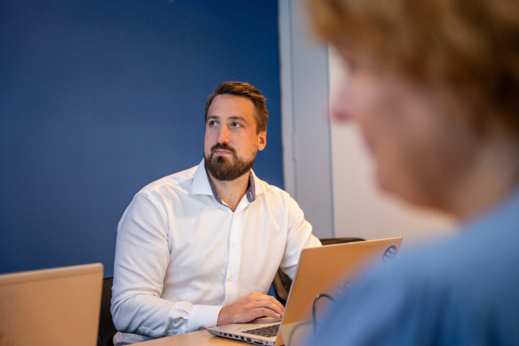 en mann med hvit skjorte som jobber med prosjekter